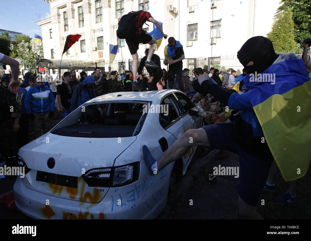 Die Demonstranten zerstören Autos mit diplomatischen Platten außerhalb der Russischen Botschaft in Kiew am 14. Juni 2014. Etwa hundert junge Menschen mit Steinen beworfen, die botschaftsgebäude und zerrissen, eine russische Flagge aus Protest gegen das, was Sie glauben, Moskauer Unterstützung separatistischer Rebellen im Osten der Ukraine. UPI/Ivan Vakolenko Stockfoto