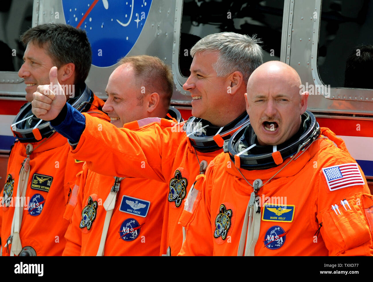 Space Shuttle Endeavour Commander Mark Kelly (rechts) schreit nach der Abfahrt mit seiner Crew und Verpflegung der Astro-van auf dem Weg zum Launchpad für letzten Flug's Bestreben im Kennedy Space Center am 29. April 2011. Der Versuch wurde Minuten später bereinigt. Hinter Kelly ist Pilot Greg Johnston und Mission Spezialisten Mike Finke und Roberto Vittori (links). Kelly ist der Ehemann von Arizona Kongressabgeordneten Gabrielle Giffords, der Wiederherstellung wurde aus einem Attentat, und am Kap die möglichen liftoff zu beobachten. UPI/Pat Benic Stockfoto