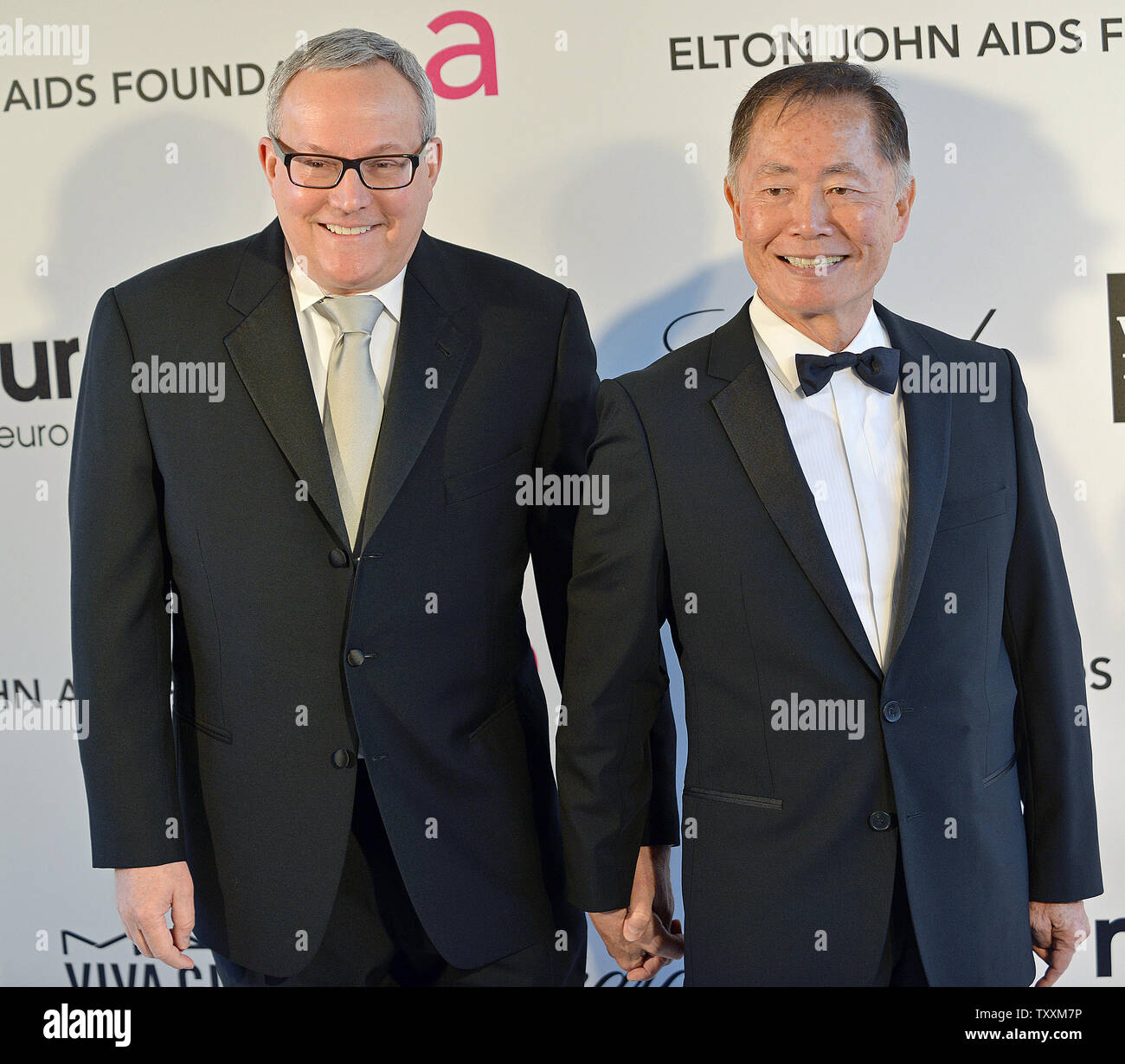 George Takei (R) und seinem Ehemann Brad Altman nehmen an der Elton John AIDS Foundation Academy Awards anzeigen Party in West Hollywood Park in Los Angeles am 24. Februar, 2013. UPI/Chris Chew Stockfoto