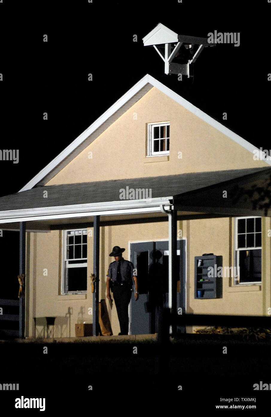 Ein Pennsylvania State Trooper schließt die Türen zu den Nickel Mines Schule Haus, als die Polizei weiter Beweise Stunden zu sammeln, nachdem ein Amoklaeufer die Schule gestürmt, selbst im Inneren verbarrikadiert und tötete mehrere Mädchen "execution Style", bevor sie die Waffe auf sich selbst, in Nickel Mines, Pennsylvania am 2. Oktober 2006. (UPI Foto/Kevin Dietsch) Stockfoto