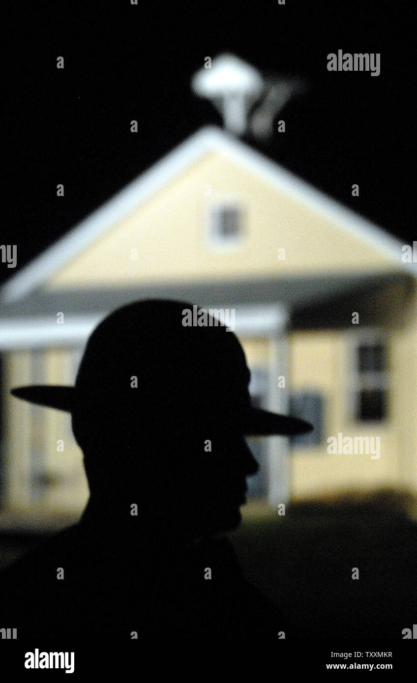 Pennsylvania State Trooper Hollway wird durch die Nickel Mines School House Silhouette als die Polizei kollektive Beweise Stunden weiter nach einem Amoklaeufer die Schule gestürmt, Verbarrikadieren sich innen und töteten mehrere Mädchen "execution Style", bevor sie die Waffe auf sich selbst, in Nickel Mines, PA am 2. Oktober 2006. (UPI Foto/Kevin Dietsch) Stockfoto