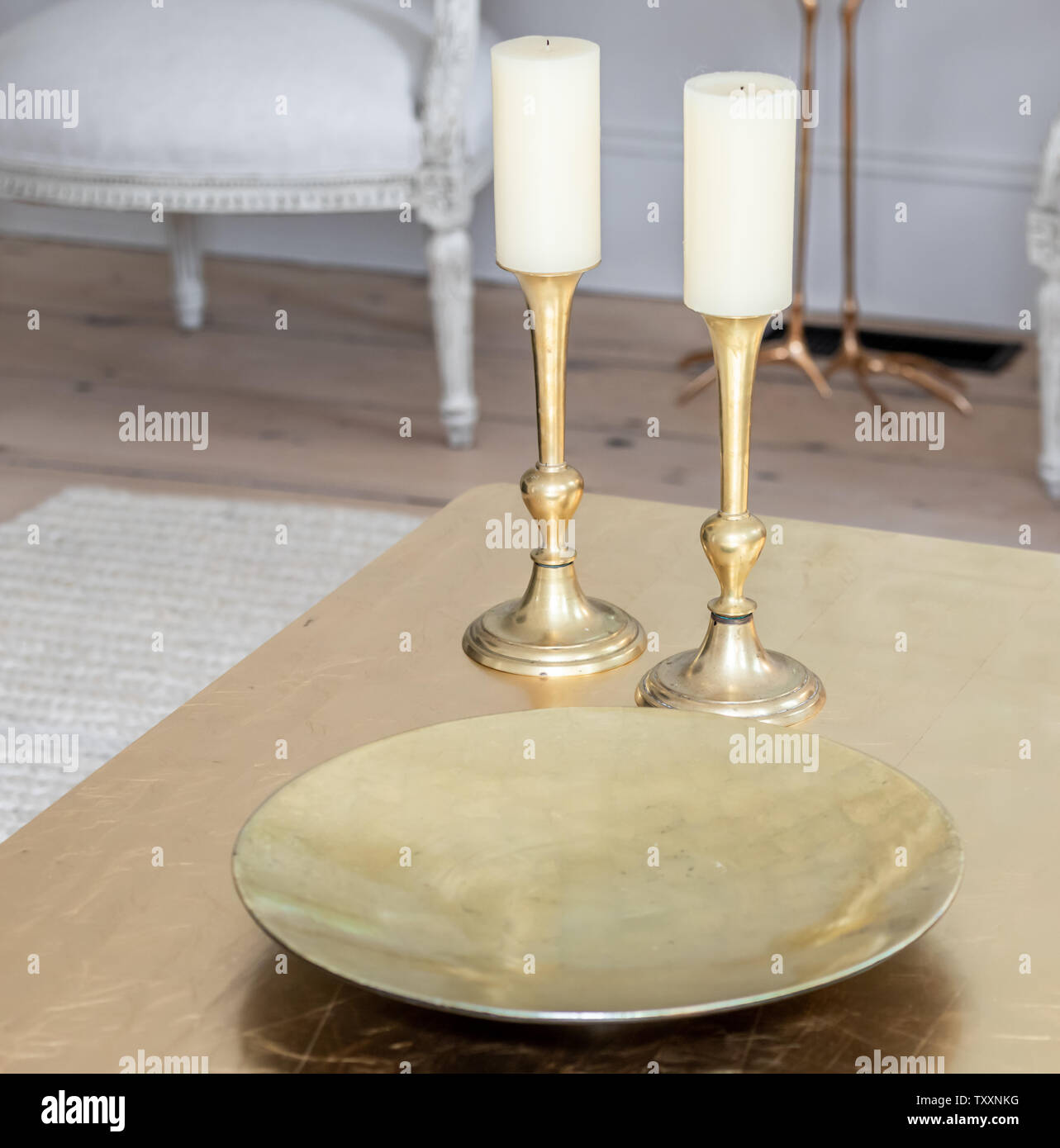 Paar brass candle Sticks und ein messing platte auf einem Tisch Stockfoto