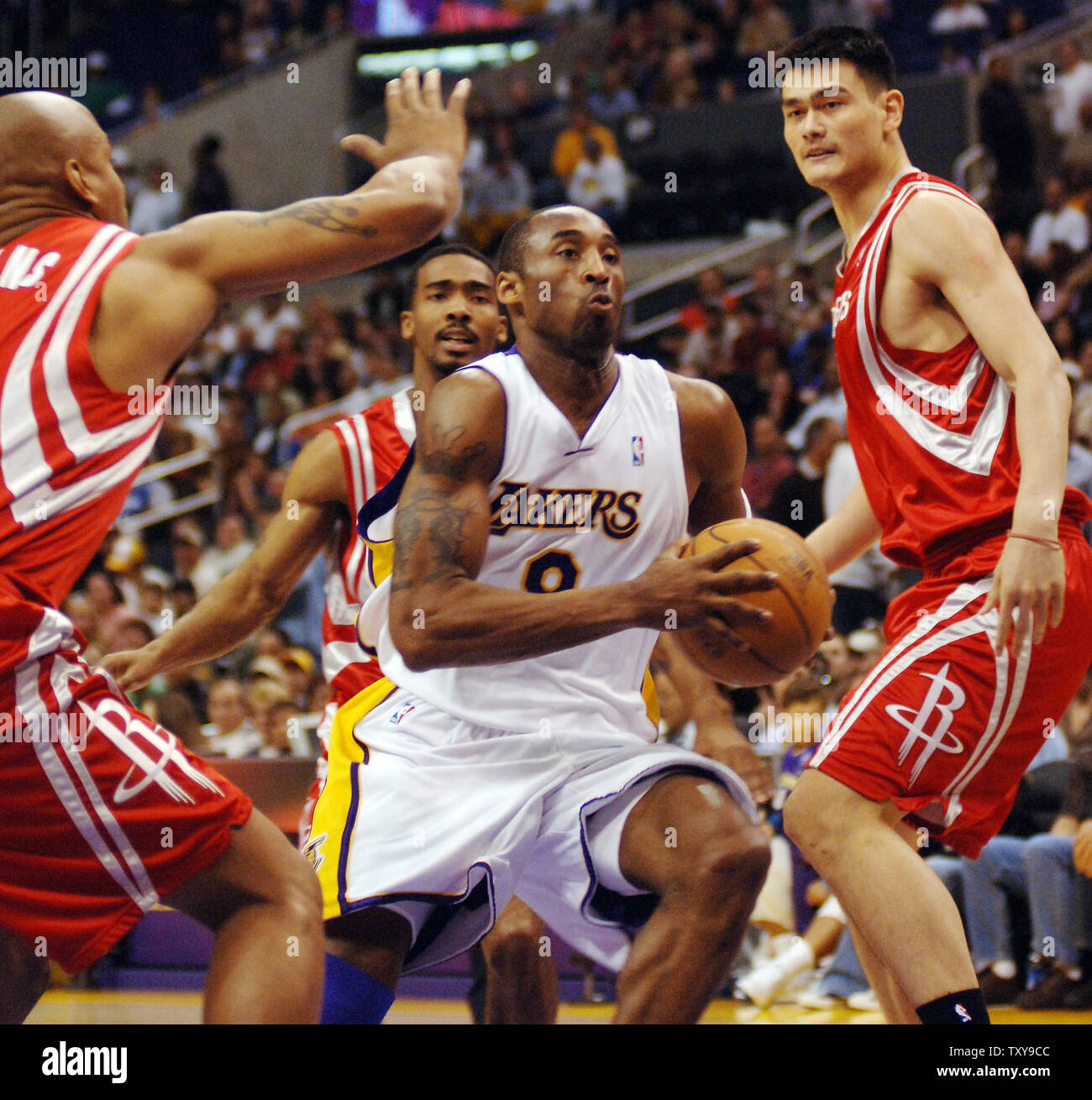 Los Angeles Lakers 'guard Kobe Bryant splits Verteidiger Keith Bogans (L) und Yao Ming Houston Rockets', wie er die Fahrspur zu zählen zwei seines Spiels - Höhe 43 Punkte, während der ersten Hälfte Aktion bei Staples Center in Los Angeles, Kalifornien am 2. April 2006. Es war der 23. Spiel von 40 oder mehr Punkte Binden eines Lakers single - würzen Aufzeichnung von Elgin Baylor in 1962-63. Die Lakers besiegten die Raketen 104-88. (UPI Foto/Jim Ruymen) Stockfoto