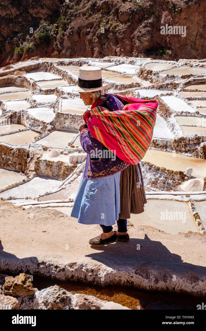 Einheimische peruanische Ureinwohner auf Salineras de Maras / Maras Salzbergwerk. Salzgewinnung in Maras Salinen, Terrassen und Teichen im Heiligen Tal von Peru. Stockfoto