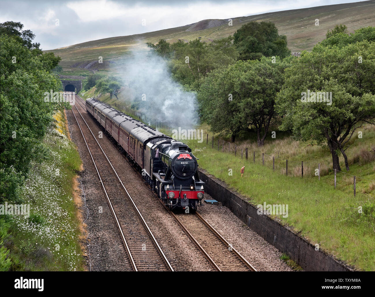 Ribblehead, North Yorkshire, UK. 25. Juni 2019. "Die Dalesman' Dampf Ausflug von Chester nach Carlisle und zurück. Hier, auf der Rückfahrt von Carlisle gesehen, die sich aus blea Moor Tunnel auf der Settle-Carlisle Railway Line, Ribblehead, North Yorkshire. Halden und die Lüftungsschlitze aus blea Moor Tunnel kann über dem Tunnel Eingang gesehen und auch weiter oben auf dem Hügel. Der Zug wird von einer 1940 stanier Klasse 8 F Lokomotive. Quelle: John Bentley/Alamy leben Nachrichten Stockfoto