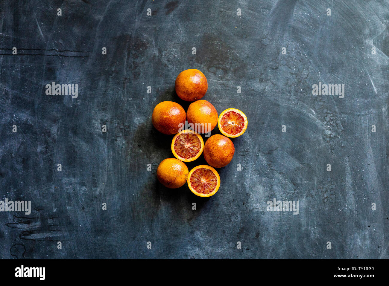 Flach rot geschnitten exotische Orangen, dunklen Essen auf schwarze Flächen Stockfoto