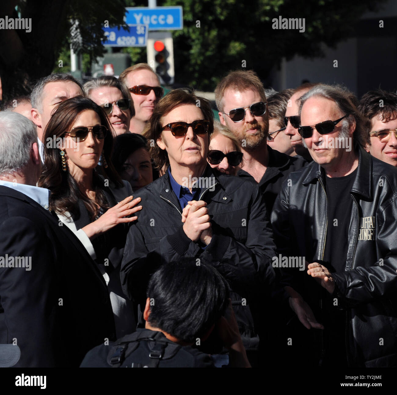 Ehemalige Beatle Paul McCartney (C) und seine Frau Nancy Shevell (L) hören Kommentare während einer enthüllungsfeier McCartney ehrt mit dem 2.460 th Stern auf dem Hollywood Walk of Fame in Los Angeles am 9. Februar 2012. Auf der Suche nach Rechts ist Musiker Neil Young. UPI/Jim Ruymen Stockfoto