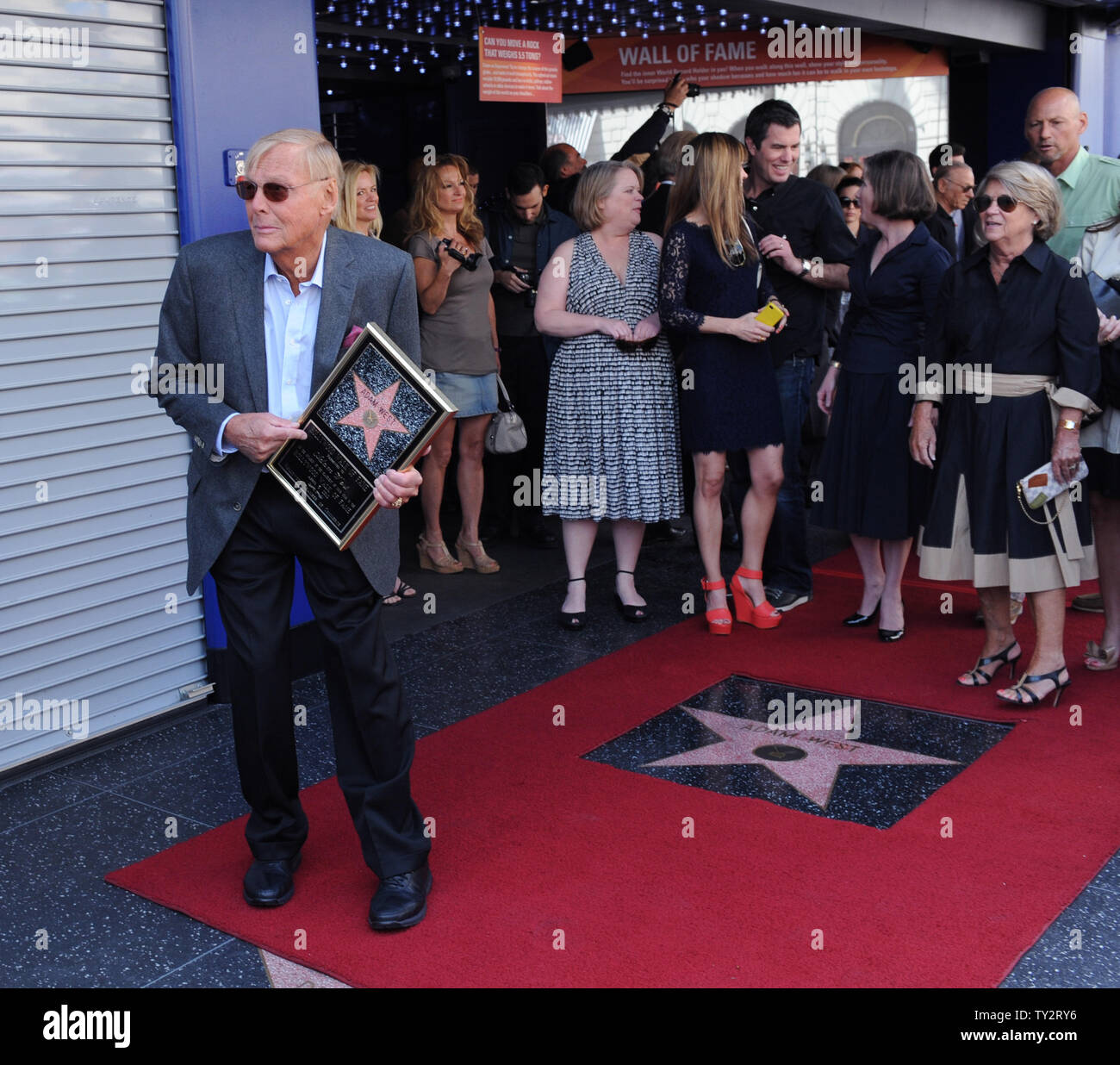 Schauspieler Adam West hält eine Replik Plaque und wird spielerisch mit Fotografen zur Freude der Familie, während einer enthüllungsfeier ihn ehrt mit dem 2.468 th Stern auf dem Hollywood Walk of Fame in Los Angeles am 5. April 2012. UPI/Jim Ruymen Stockfoto