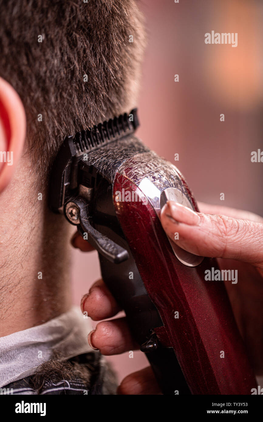 Haarschnitt Nahaufnahme. Hände halten einen Haarschneider. Friseur-, Stil, Schönheit. Beauty Salon. Stockfoto