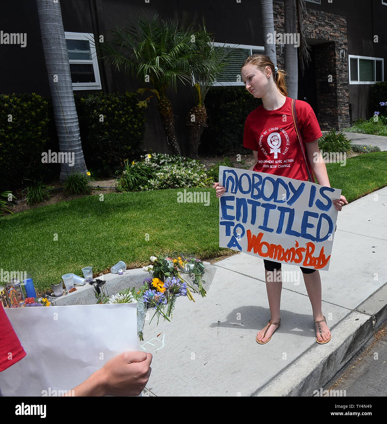 Hält eine Frau ein Zeichen außerhalb der Apartment Komplex in Isla Vista, Kalifornien am 26. Mai 2014 wo Elliot O. Rodger lebte und wo sein Rampage begann am Freitag Abend mit dem tödlichen stabbings von drei Personen. UPI/Jim Ruymen Stockfoto