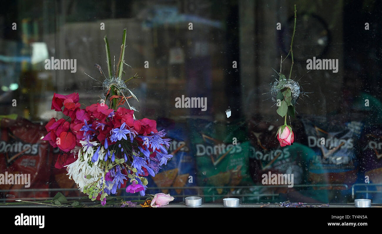 Blumen haben in bullet Bohrungen an der I.V. platziert. Deli Mart in Isla Vista, Kalifornien am 26. Mai 2014, wo Christoph Michaels-Martinez hinunter Freitag Nacht geschossen wurde, eine der Szenen von Elliot O.'s Rodger Rampage. UPI/Jim Ruymen Stockfoto