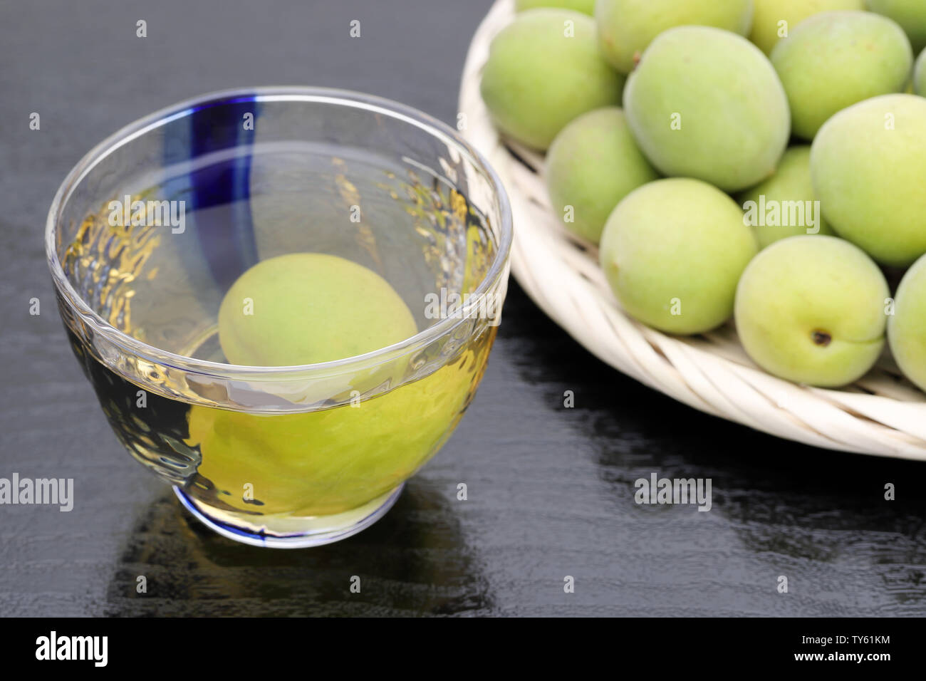 Japanische Pflaume Wein namens umeshu auf schwarzem Hintergrund Stockfoto