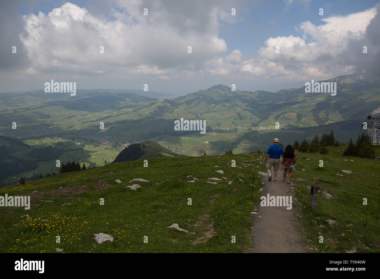 Ein Paar amerikanischer Touristen sind in Ehrfurcht, als sie an einem bewölkten Tag in den Schweizer Alpen auf einem Pfad hoch oben auf der Ebenalp der Schweiz wandern. Stockfoto