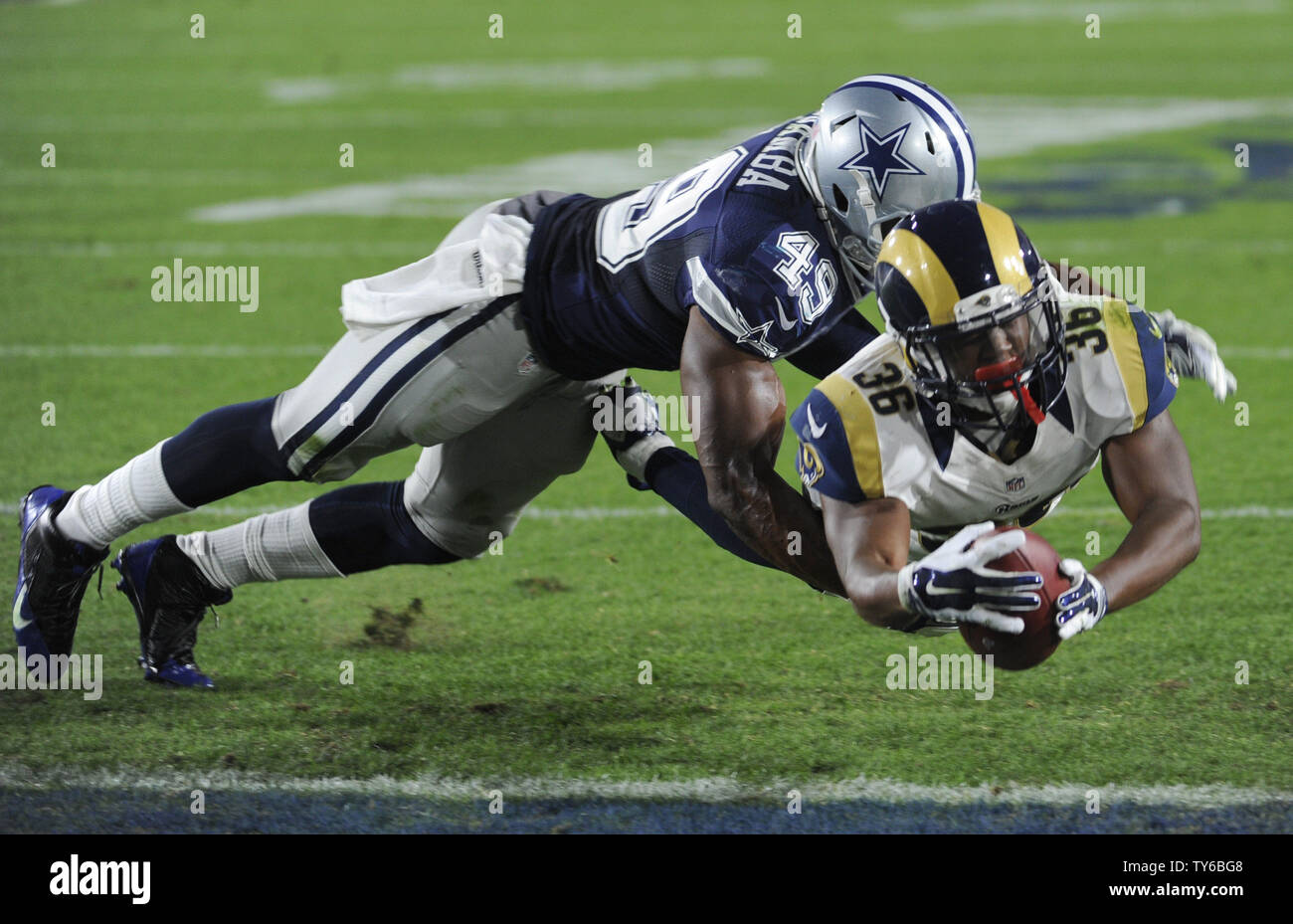 Los Angeles Rams Aaron Grün Kerben die gewinnenden Touchdown als Dallas Cowboys Henoc Muamba ihn in den letzten Minuten von einem preseason Spiel am Los Angeles Kolosseum am 13. August 2016 in Angriff nimmt. Die Rams gewannen 28 bis 24. Foto von Lori Shepler/UPI Stockfoto