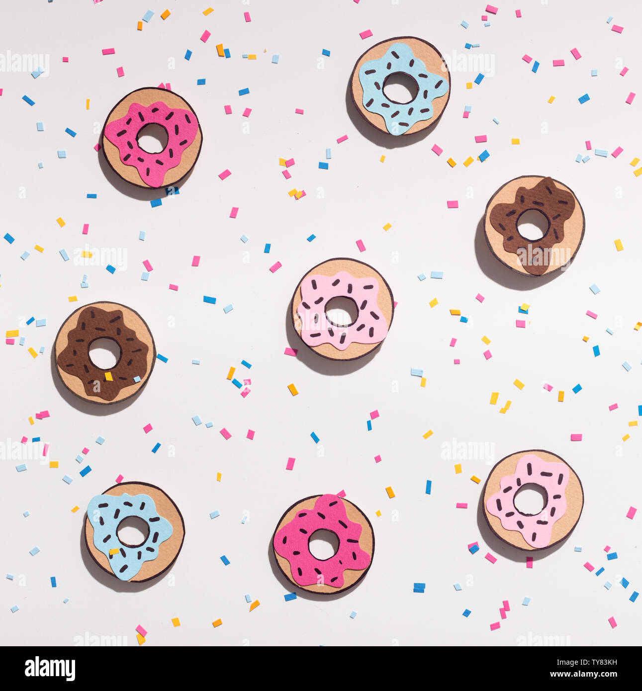 Kreative Hintergrund mit farbigen Donuts auf weißem Hintergrund Stockfoto