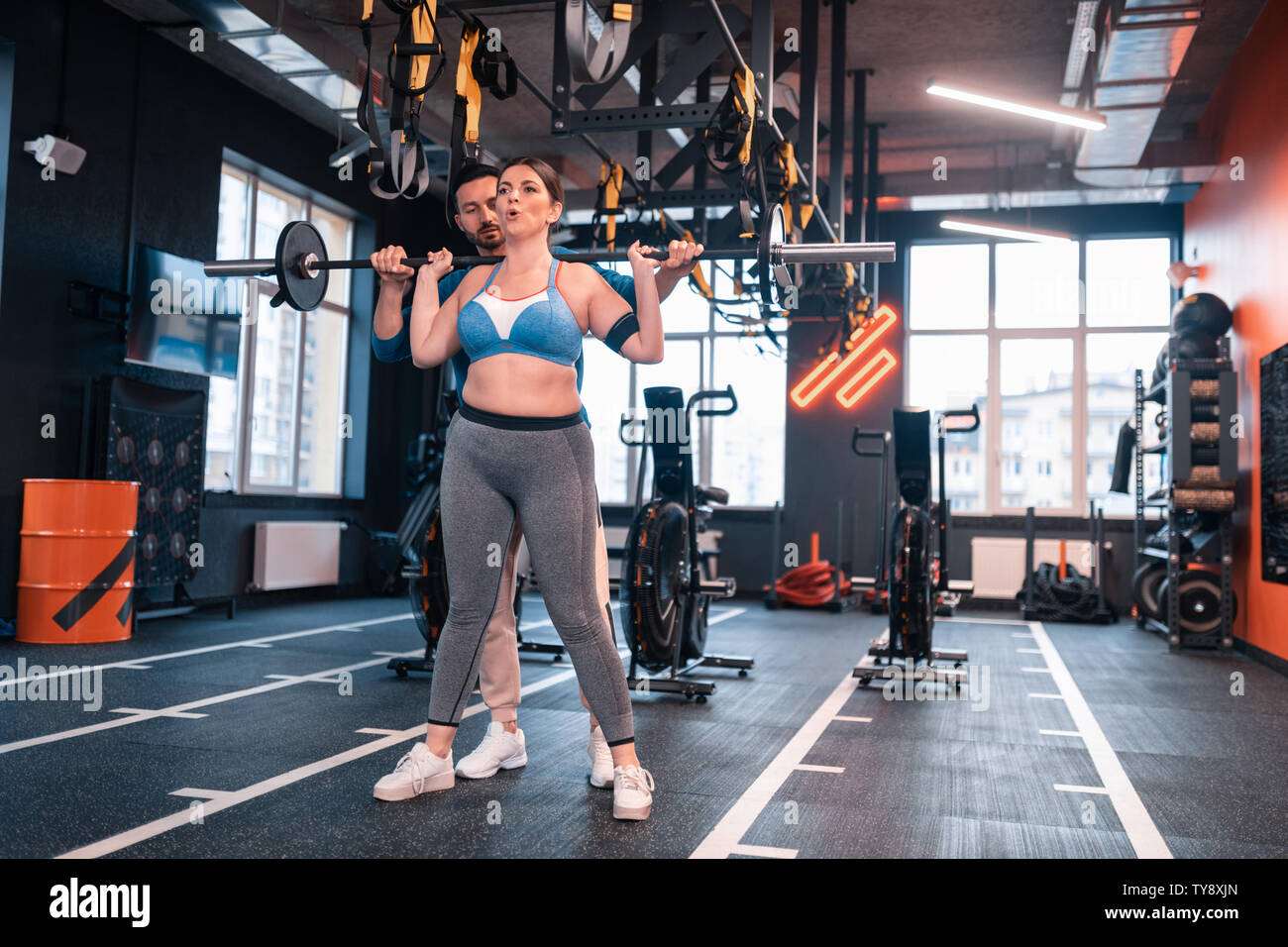 Frau kaum atmen nach dem Anheben barbell in der Nähe von Trainer Stockfoto