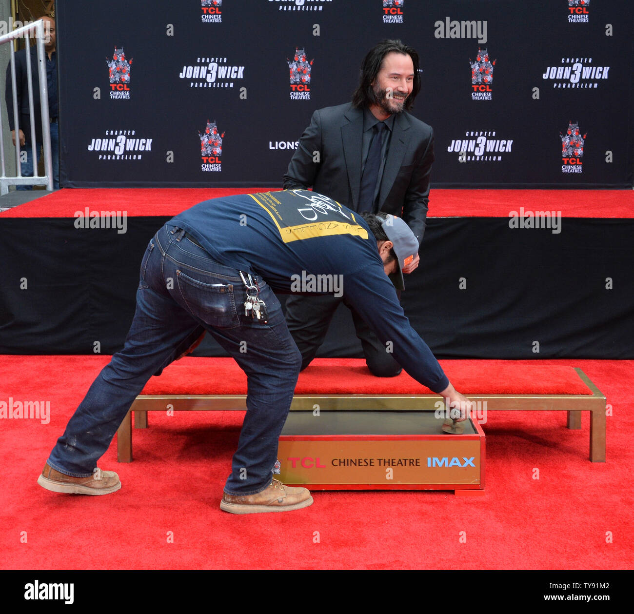 Ein Arbeiter gibt Schauspieler Keanu Reeves eine zweite Chance, seinen Namen in feuchtem Zement zu unterzeichnen, wenn Reeves nicht mit seiner Unterschrift zufrieden war, als er in einer Hand und Fußabdruck Zeremonie nimmt ihn zu verewigen auf dem Vorplatz des TCL Chinese Theatre (ehemals Grauman's) in den Hollywood in Los Angeles am 14. Mai 2019. Foto von Jim Ruymen/UPI Stockfoto