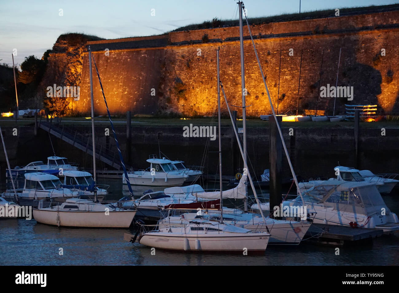 Beleuchtet alte steinerne Festung am Meer auf der französischen Insel Oléron und seinen Hafen bei Dämmerung Stockfoto