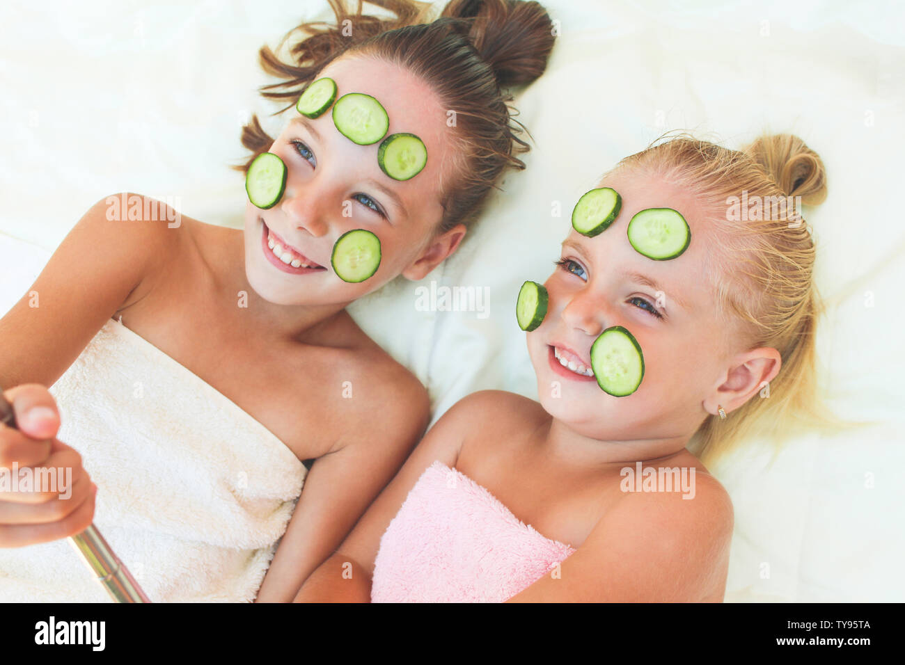 Schöne Mädchen mit Gesichtsmaske der Gurke. Kinder Bilder von ihr selbst  getroffen Stockfotografie - Alamy