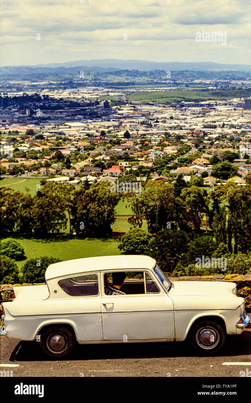 Neuseeland, Nordinsel, Auckland. Ein alter Ford Anglia Auto mit einem Fahrer mit Blick über die Stadt. Foto: © Simon Grosset. Archiv: Bild von digitalisierten Stockfoto