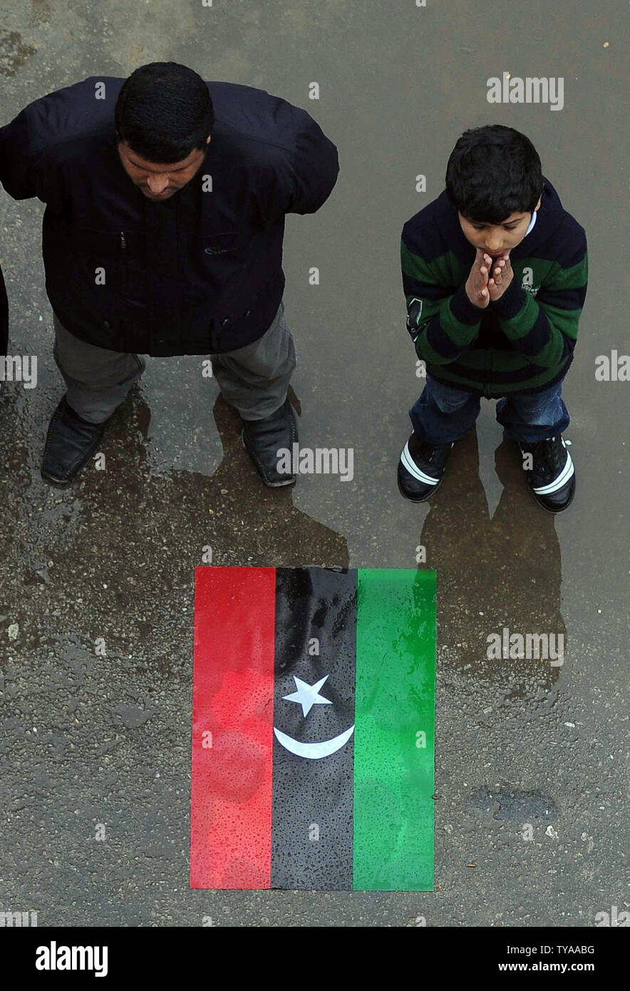 Die Demonstranten vor der alten nationalen Flagge, wie sie Parolen gegen den libyschen Staatschef Muammar Gaddafi in der Nähe des Hafens von Benghazi, Libyen entlang der Mittelmeerküste am 6. März 2011 schreien. Loyal und Rebellen weiterhin für die Kontrolle über das Land zu kämpfen. UPI/Mohamaad Hosam Stockfoto