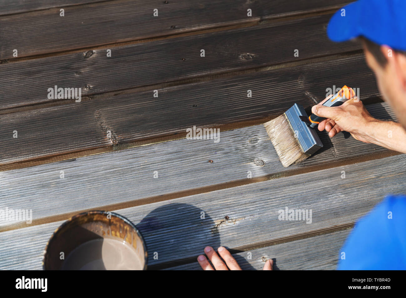 Mann stellt Holz terrasse mit Holz Schutzlack Stockfoto