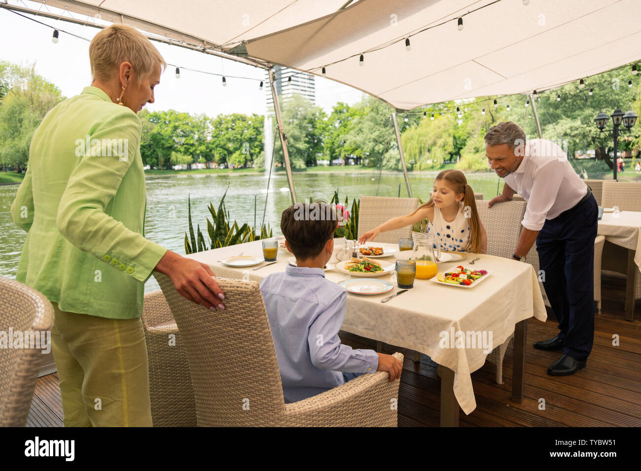 Großeltern, Enkelkinder das Frühstück im Freien in Stockfoto