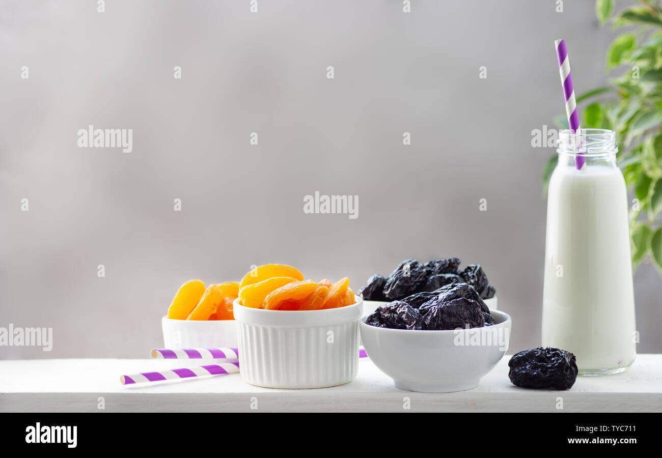 Konzept gesunde Ernährung, Vegetarismus Ernährung. Joghurt, getrocknete Aprikosen und Pflaumen in einem weißen Schalen. Stockfoto