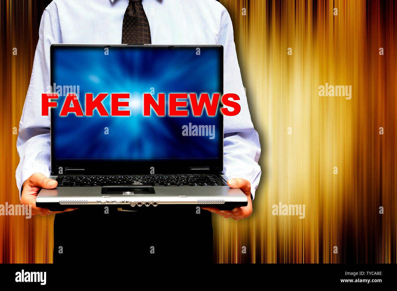 Mann hält einen Laptop mit Worten gefälschte Nachrichten auf dem Bildschirm Stockfoto