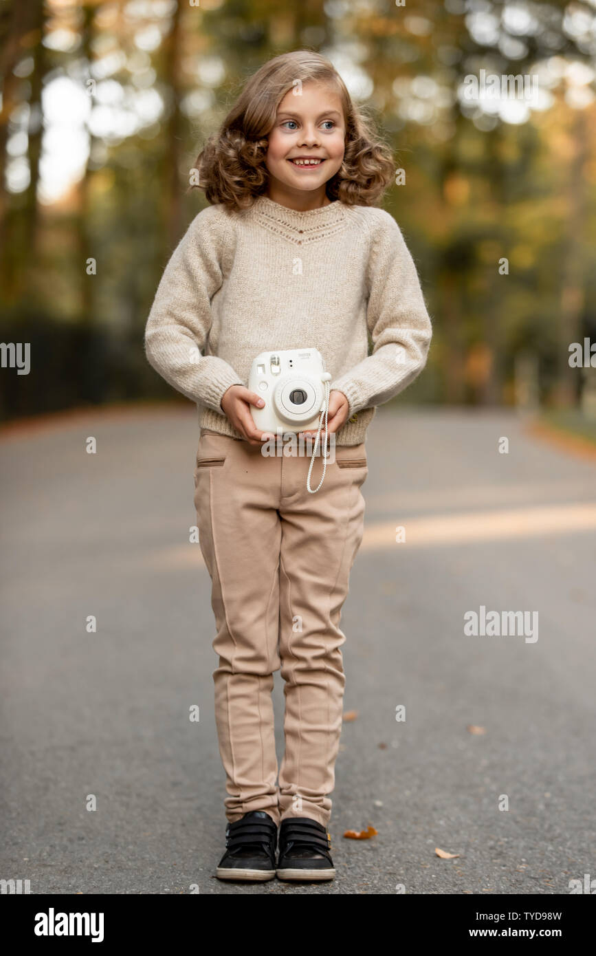 Stilvolle kind Mädchen 6-7 Jahre alt tragen Designer Blue Velvet Dress in Wald. Im Freien. Mit Blick auf die Kamera. Kindheit. Stockfoto