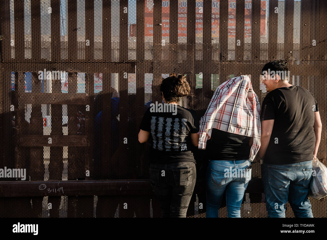 Als die Sonne untergeht einer Familie, die durch eine Grenze getrennt ist, Zaun Gespräche miteinander entlang der US-mexikanischen Grenze in Calexico, Kalifornien am 4. April 2019. Foto von Ariana Drehsler/UPI Stockfoto