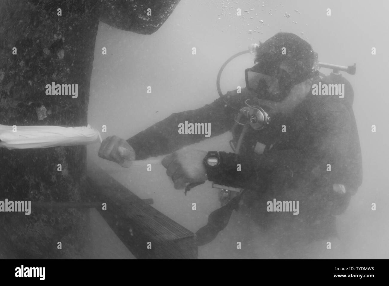 Petty Officer 1st Class Matt Ramirez, Unterwasser Bau Team (UCT) 2, Commander, Task Force (CTF) 75, sichert einem geformten kostenlos auf eine beschädigte Pylon in Diego Garcia Nov. 3, 2016 zugeordnet. CTF75 ist das primäre Expeditionary task force verantwortlich für die Planung und Ausführung der Küstengebiete Riverine operations, Beseitigung von Explosivstoffen, tauchen Engineering und Bau und Unterwasser Bau in den USA 7 Flotte Bereich der Operationen. Stockfoto