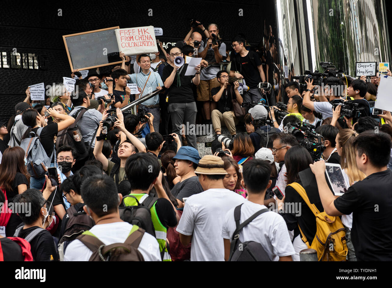 Die Demonstranten und drücken Sie sammeln außerhalb der Britischen Generalkonsulat während der Demonstration. Aktivisten protestieren gegen die Auslieferung Bill sammelte, um die verschiedenen Nation Botschaften und Konsulate das Problem mit dem chinesischen Präsidenten Xi Jinping bei den diese Woche stattfindenden G-20-Gipfel in Japan zu erhöhen. Stockfoto