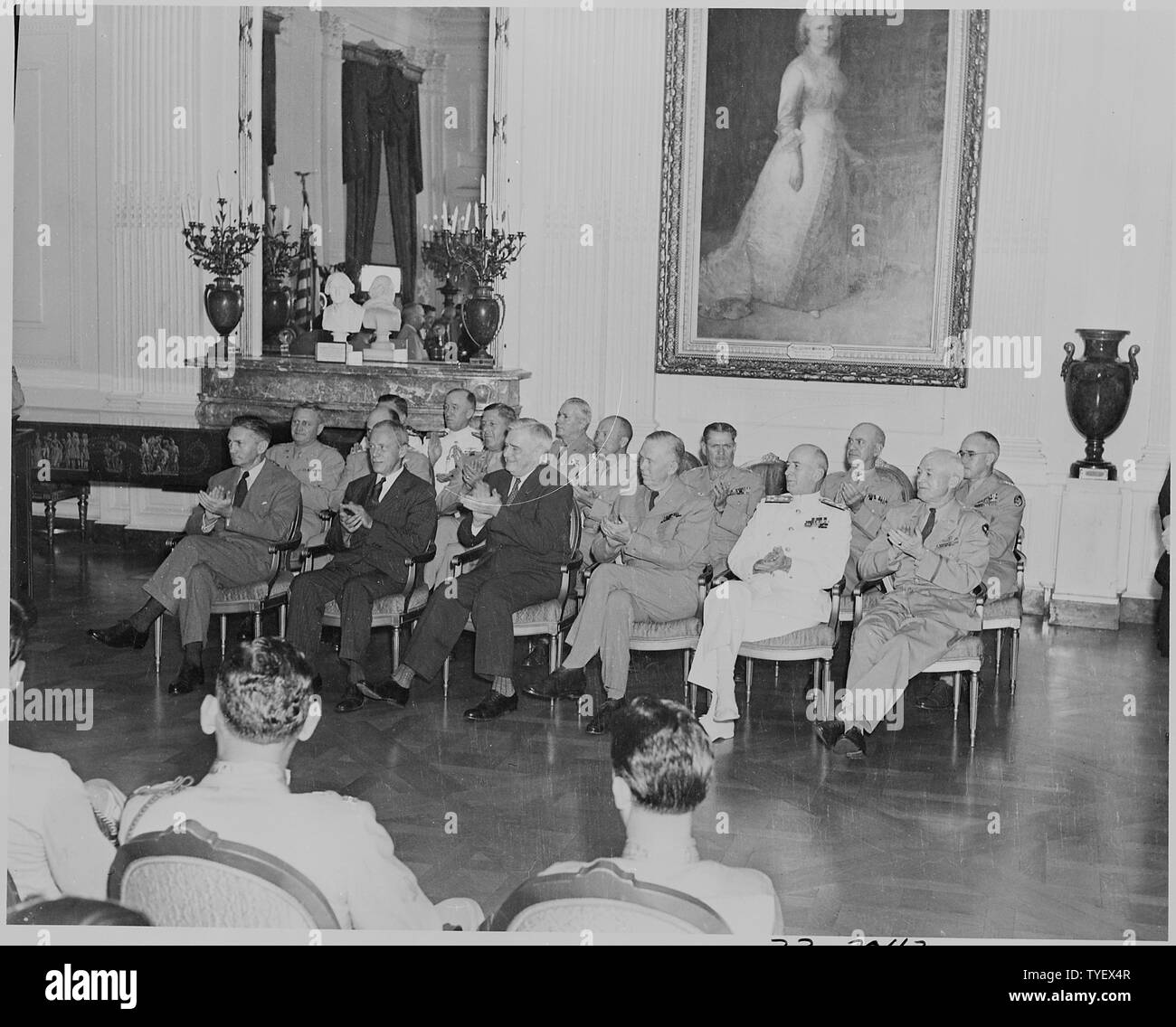 Foto von Würdenträgern applaudieren während Ehrenmedaille Siegerehrung im East Room des Weißen Hauses: (vordere Reihe, von links nach rechts) Sekretär der Marine James Forrestal; Kriegsminister Henry Stimson; unbekannter Mann; General George C.; Fleet Admiral William Leahy; General Henry Hap Arnold. Stockfoto