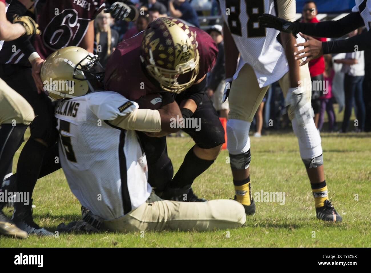 Ein Spieler von der Matthew C. Perry High School Football team Samurai läuft durch einen Verteidiger aus der Humphreys High School Blackhawks Fußballmannschaft von U.S. Army Garrison, Lager Humphreys, Korea, während im Fernen Osten Abteilung II Meisterschaft Nov. 5, 2016, in der Marine Corps Air Station Iwakuni, Japan. Am Ende des vierten Quartals, die Samurai Beat der Blackhawks 44-6 bilden Sie den Fernen Osten Abteilung II Meister. Stockfoto