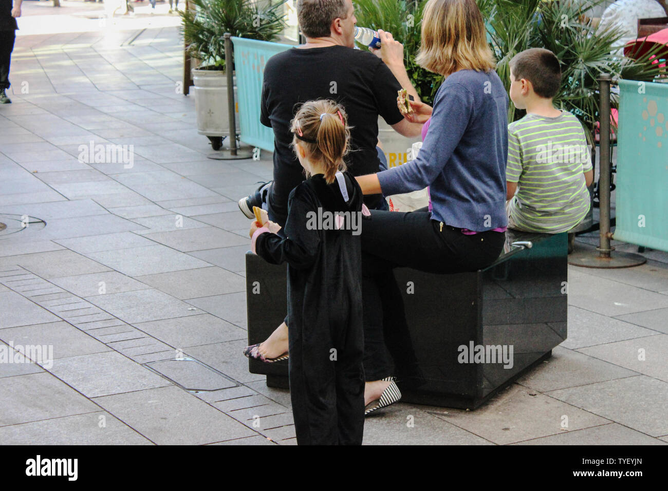 Juni 2019, Cardiff, Wales. Niedliche Kinder mit ihren Eltern im freien St David's Dewi Sant. Blonde Mädchen mit Brille, PRAM/drücken Stuhl Stockfoto