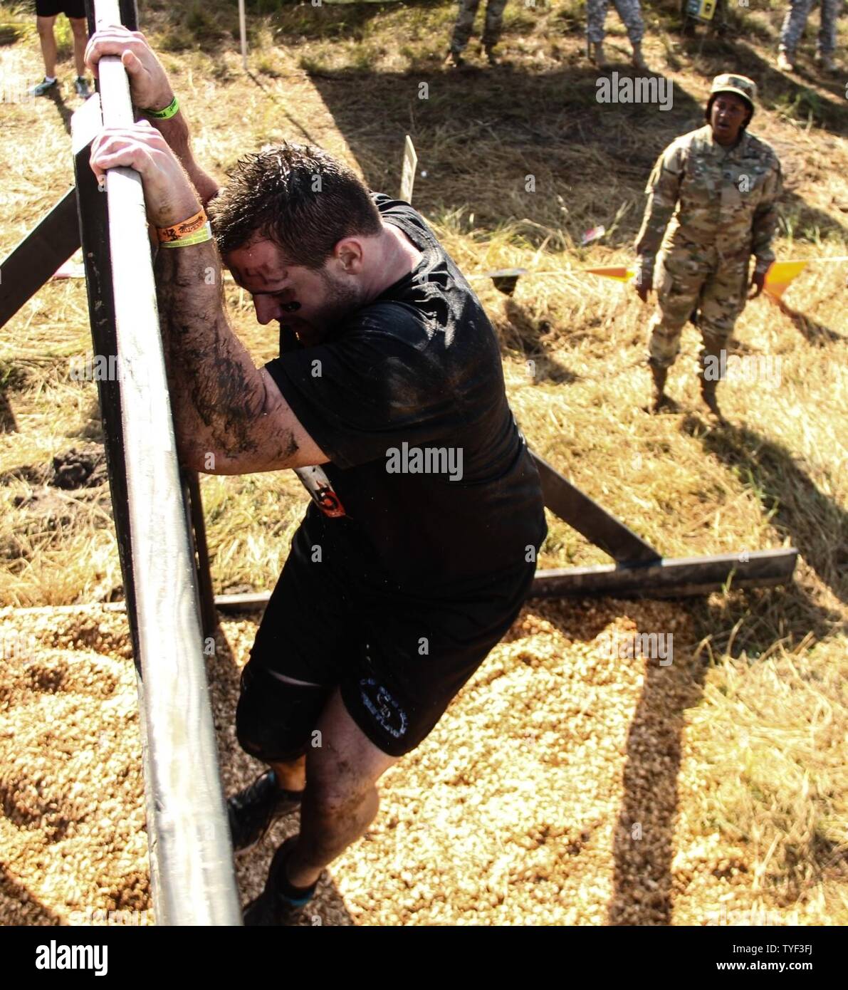 Armee Sgt. 1. Klasse Michele S. Bell, 143 Sustainment Command (Auslandseinsätze), Prost auf einen Konkurrenten klettern die Berliner Mauer Hindernis während der harten Mudder Endurance Challenge Nov. 5, 2016, in Palm Bay, Fla. Bell, ein Eingeborener von Trinidad, ist seit mehr als 20 Soldaten der 143. sustainment Command (Auslandseinsätze), die moralische Unterstützung für dieses internationale sportliche Extravaganz, die aus einer 10-12 Meile Kurs mit fast zwei Dutzend Hindernisse, Tests individuelle Kraft und Ausdauer durch Teambildung und Zusammenarbeit in einer Gruppe. Seit 2012 ist die Armee finden hat partnered Stockfoto