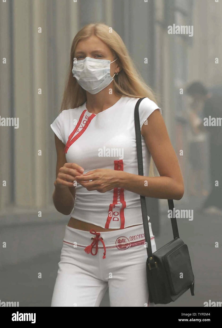 Eine Frau, die durch das Tragen von schützender Maske Spaziergänge durch einen schweren Smog in Moskau am 6. August 2010. Die russische Hauptstadt war in den Datensatz dicker Rauch verursacht durch Temperaturen bis 100 F (38 C) und mehrere Tage in der Nähe von Wald und Torffeuer. UPI/Alex Volgin Stockfoto