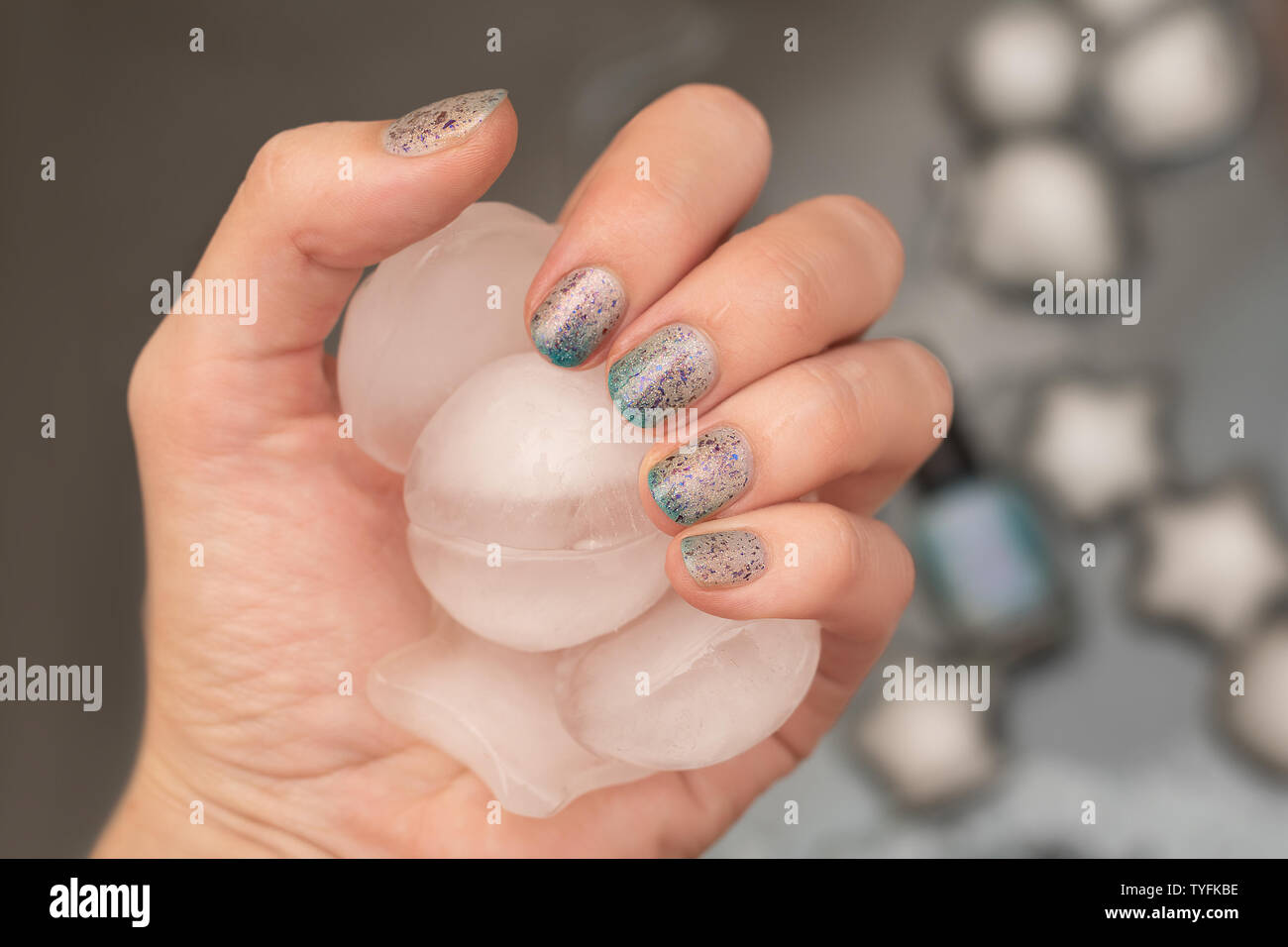 Weibliche hand mit thermischen glitter Nail Design holding Eis Stockfoto