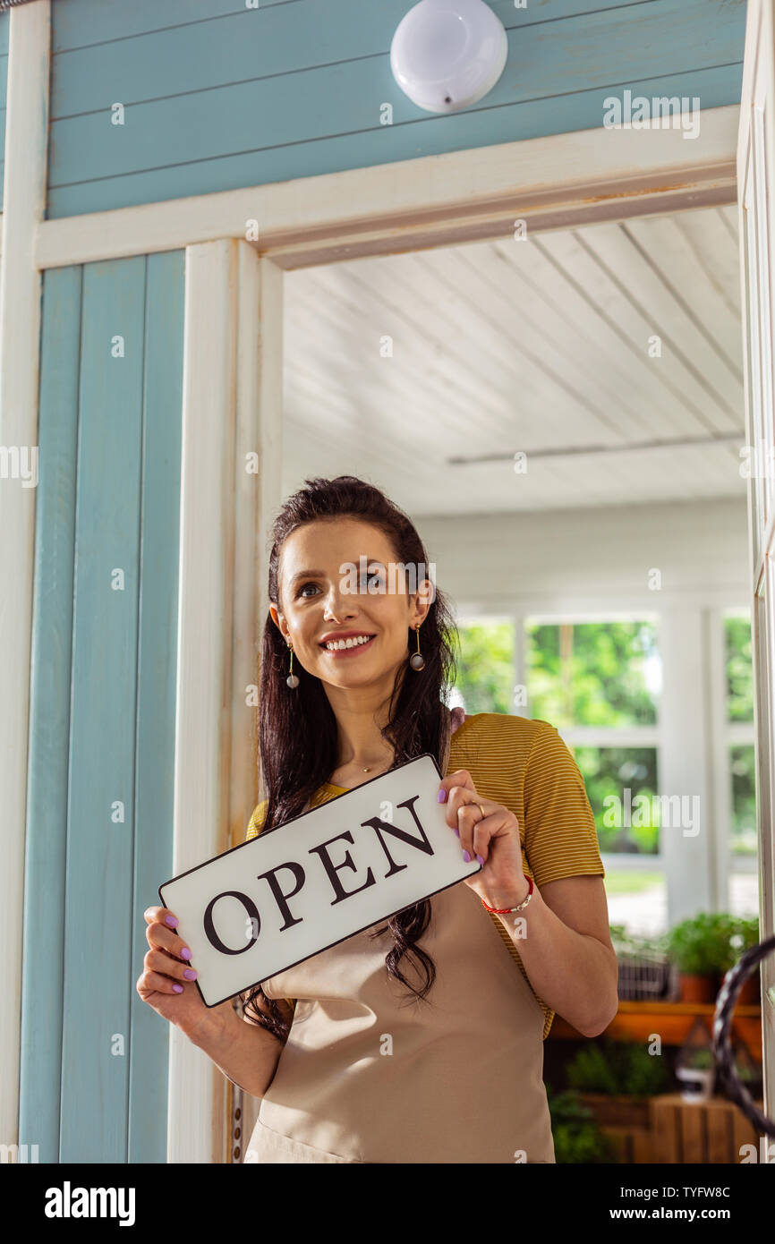 Glückliche Frau, die auf der Veranda Ihrer Shop. Stockfoto