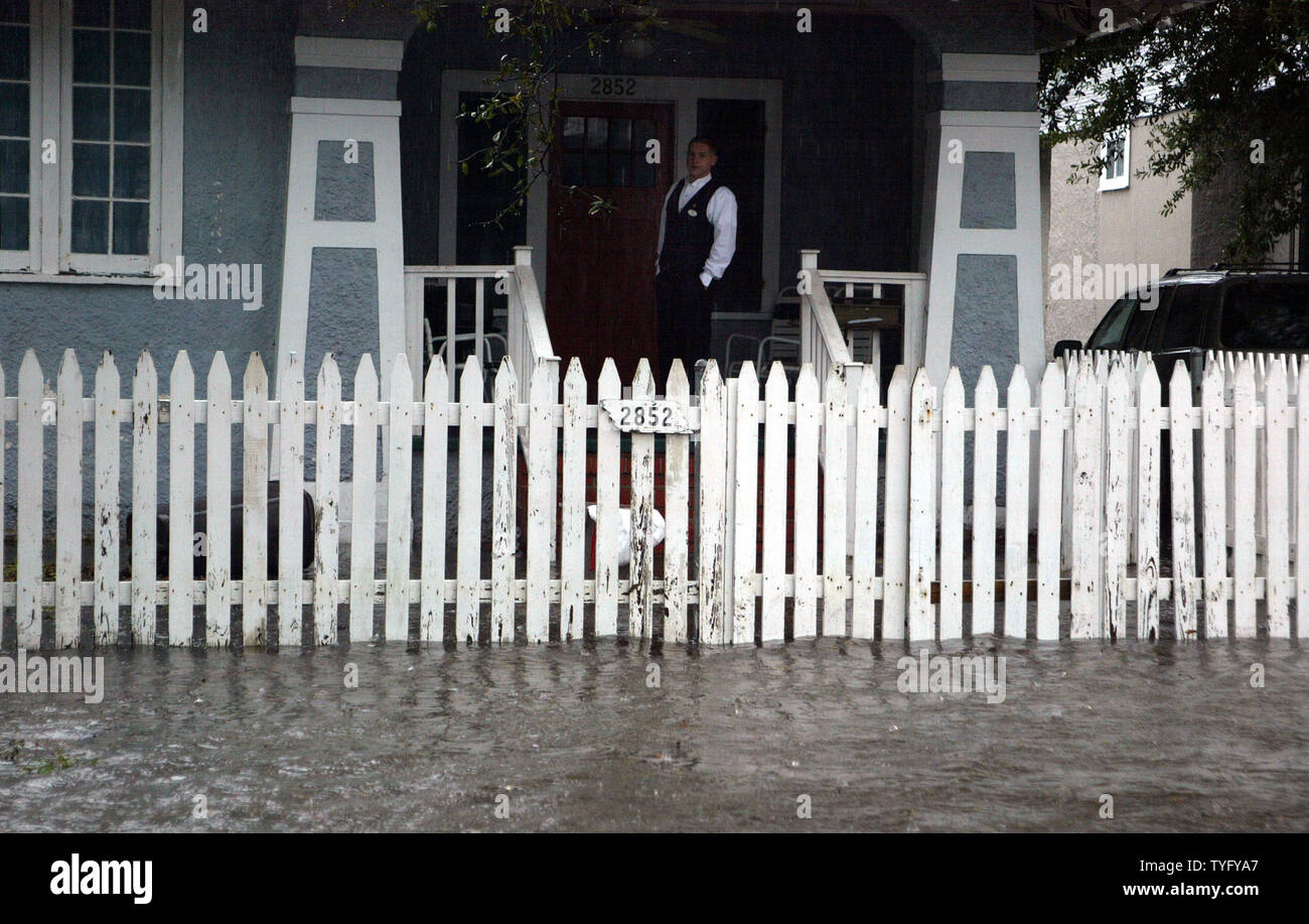 Nate Crosby, wartet auf seinem Portal in Uptown New Orleans für Hochwasser zu treten, damit er gehen kann am 21. Dezember 2006 zu arbeiten. Schwere Regenfälle in den letzten 24 Stunden füllten viele Straßen der Gegend, einige mit einem Fuß oder mehr Wasser. Die Pumpstationen kämpfen, um Schritt zu halten, und werden eng Seit der katastrophalen Überschwemmungen nach dem Hurrikan Katrina im August 2005 beschädigt viele von ihnen gesehen. (UPI Foto/A.J. Sisco) Stockfoto