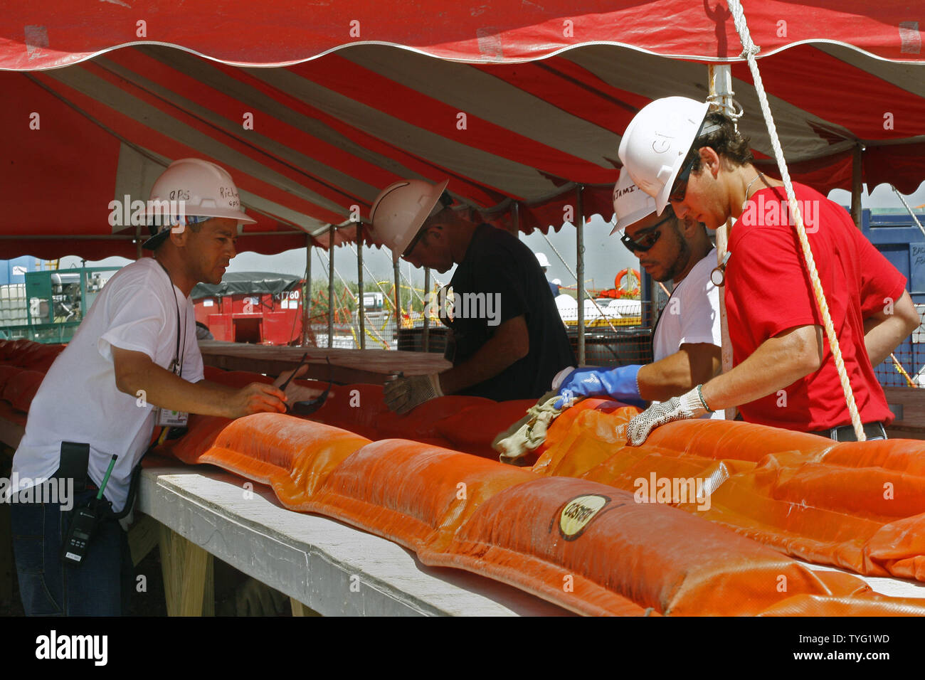 BP Leiharbeiter Reparatur Ölinhalt Ausleger, die nach dem Sammeln von Öl aus dem Deepwater Horizon Ölpest im Golf von Mexiko gereinigt wurden, an der BP Cocodrie Staging Area in Terrebonne Parish, 4. Juli 2010, in Cocodrie, Louisiana. UPI/A.J. Sisco. Stockfoto