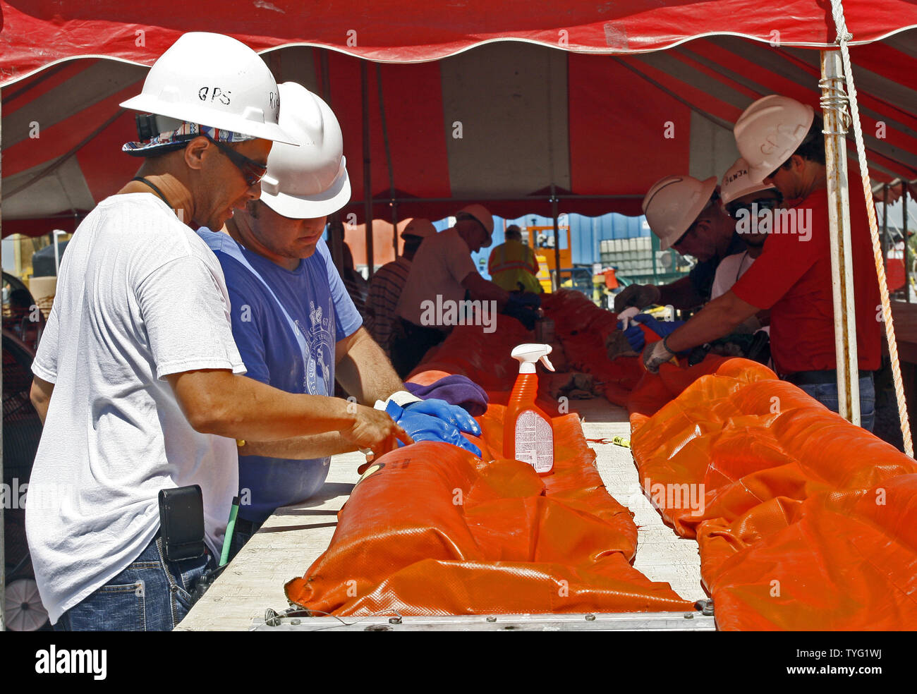 BP Leiharbeiter Reparatur Ölinhalt Ausleger, die nach dem Sammeln von Öl aus dem Deepwater Horizon Ölpest im Golf von Mexiko gereinigt wurden, an der BP Cocodrie Staging Area in Terrebonne Parish, 4. Juli 2010, in Cocodrie, Louisiana. UPI/A.J. Sisco. Stockfoto