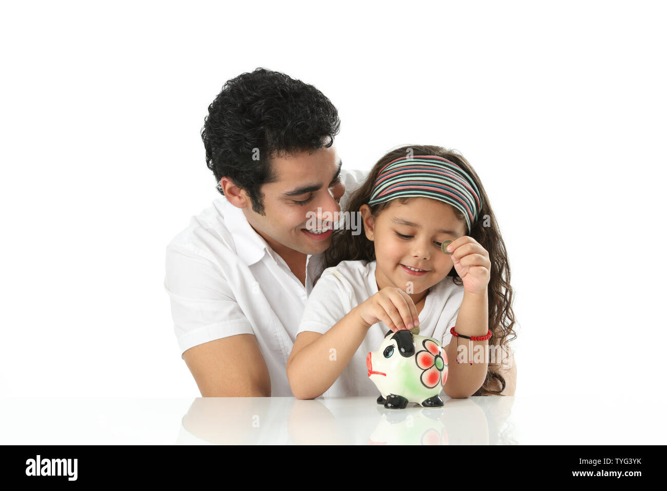 Mädchen mit ihrem Vater ein Sparschwein Münzen Inbetriebnahme Stockfoto