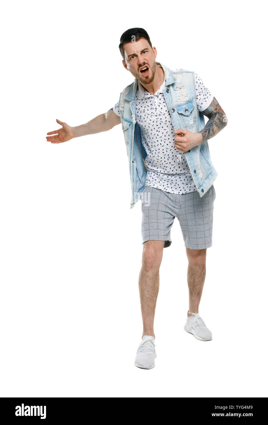 Der Mann schreit. Aggressive Kerl in Tattoos am Rahmen schreien und seine Hände wieder angezeigt. Stilvolle bärtigen Kerl sehr empört über das, was geschieht Stockfoto