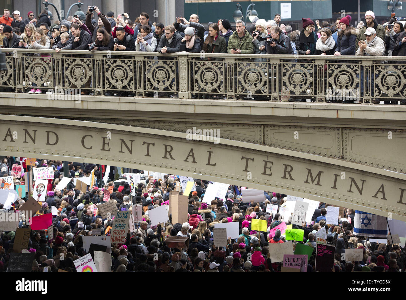 Zuschauer, die entlang einer erhöhten Fahrbahn zusehen, wie Massen März 42nd Street im März den Frauen die Wahl von Donald Trump als Präsident der Vereinigten Staaten am 21. Januar 2017 in New York City zu protestieren. Frauen marschiert sind, die in den Städten im ganzen Land. Gestern, Donald Trump wurde der 45. Präsident der Vereinigten Staaten zu einer Vereidigung Zeremonie in Washington DC. Foto von Monika Graff/UPI Stockfoto