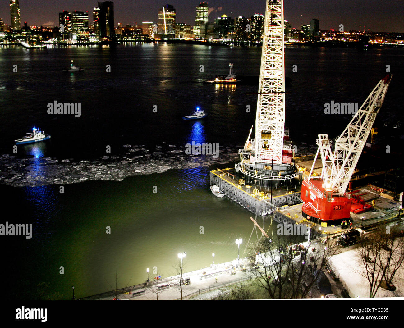 Nacht fällt als zwei Kräne verwendet werden, um die ruinierte uns Flugzeug, welches eine Notlandung in den Hudson River vor zwei Tagen gemacht, von der Unterseite des Flusses am 17. Januar 2009 in New York zu erholen. Eisige Bedingungen haben die Erholung der Flug verspätet, so dass die Black Box entfernt werden kann und das Wrack inspiziert. (UPI Foto/Monika Graff) Stockfoto
