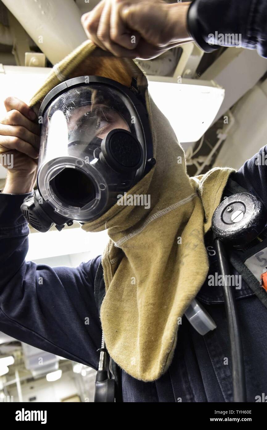 Meer (Nov. 9, 2016) Pettyu Officer 3. Klasse Lukas Schmalix aus Brooklyn, N.Y., zieht ein Flash Haube während einer Klasse bravo Brandschutzübung an Bord der USS Ross (DDG71) Nov. 9, 2016. Ross, einer der Arleigh-Burke-Klasse geführte-missile Destroyer, Vorwärts - Rota, Spanien bereitgestellt werden, ist die Durchführung von naval Operations in den USA 6 Flotte Bereich der Maßnahmen zur Unterstützung der US-amerikanischen nationalen Sicherheitsinteressen in Europa und Afrika. Stockfoto