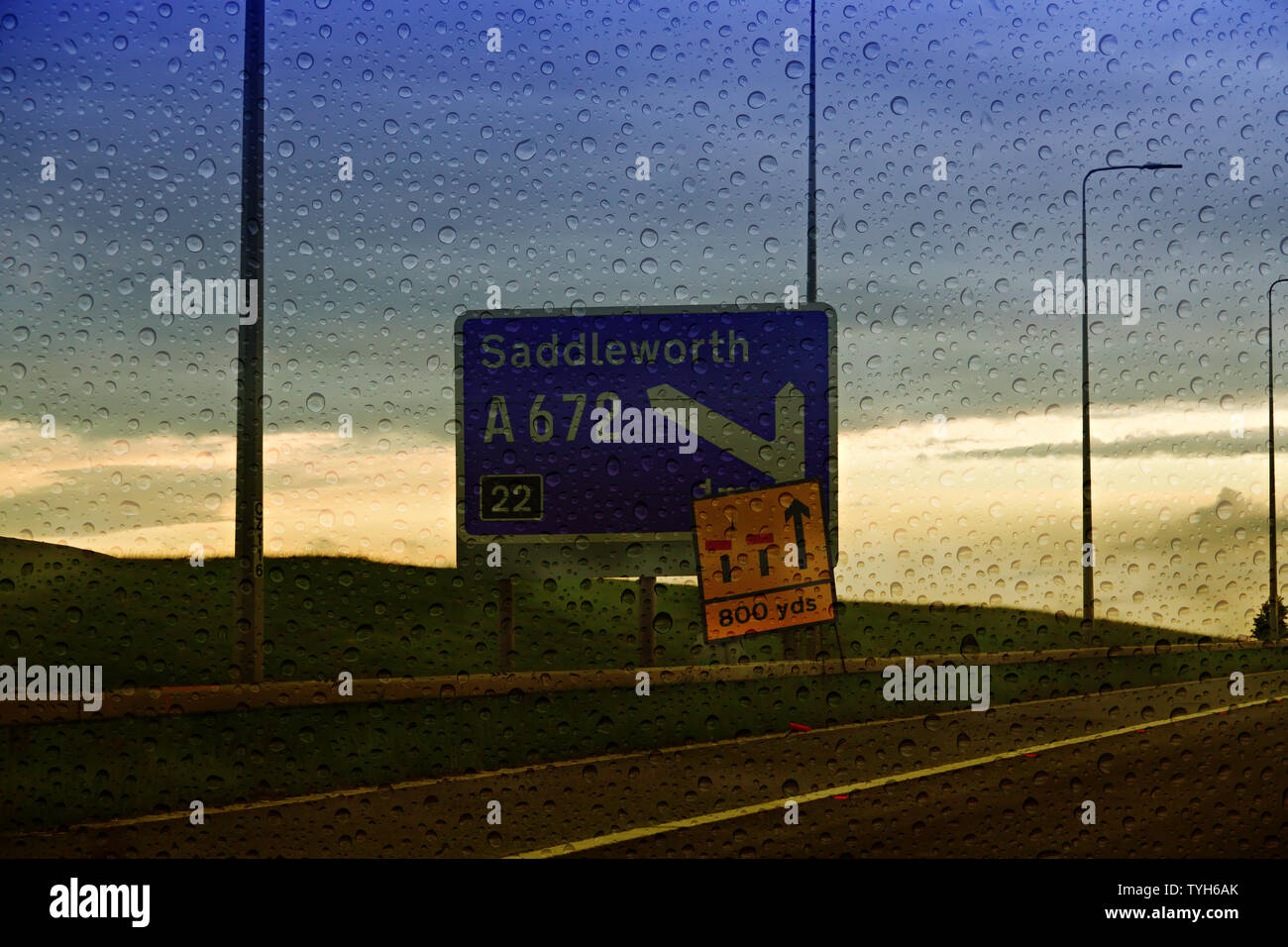 Autobahn M62 Zeichen für Saddleworth Moor in der Dämmerung mit Regentropfen auf der Windschutzscheibe Stockfoto