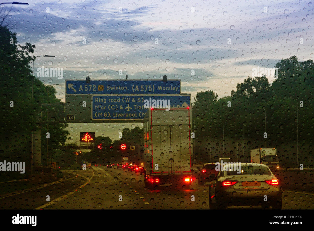 M 62 Verkehr auf der Autobahn bei Dämmerung mit Regentropfen auf der Windschutzscheibe Stockfoto